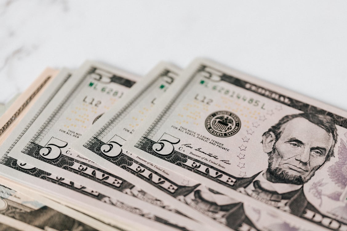 Stack of US dollar banknotes on marble board